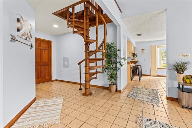 tiled entrance foyer featuring a textured ceiling