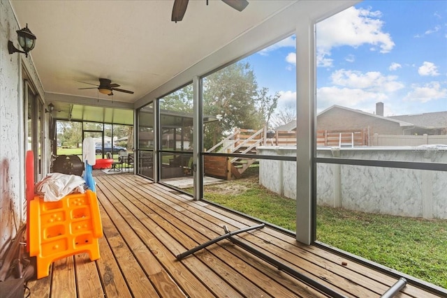 unfurnished sunroom featuring ceiling fan