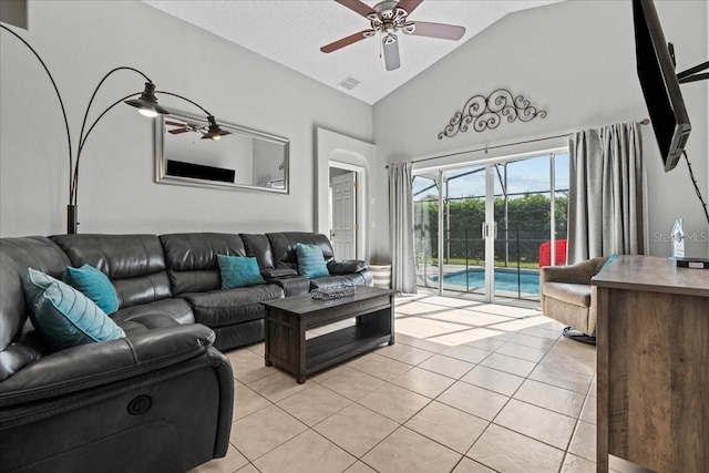 living room featuring ceiling fan, a textured ceiling, light tile patterned floors, and high vaulted ceiling