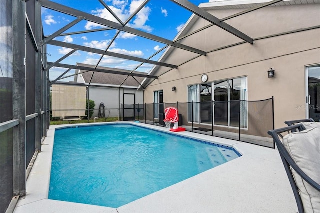 view of swimming pool featuring glass enclosure and a patio area