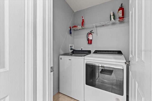 laundry room featuring washer and dryer and light tile patterned floors