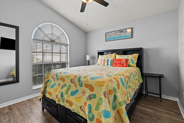 bedroom with ceiling fan, dark hardwood / wood-style floors, a textured ceiling, and lofted ceiling