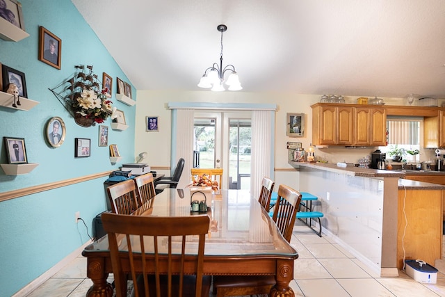 tiled dining room with a chandelier and vaulted ceiling