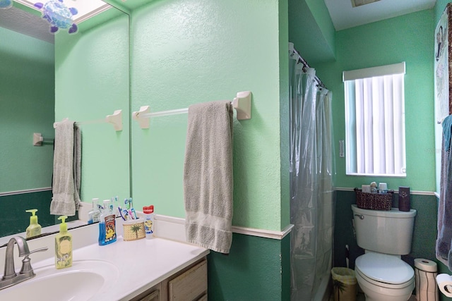 bathroom featuring toilet, vanity, and a shower with shower curtain