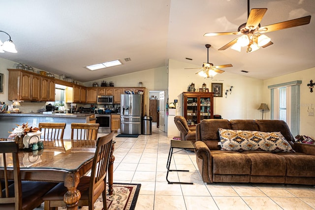 dining space with vaulted ceiling, light tile patterned floors, ceiling fan, and plenty of natural light