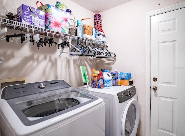 laundry area featuring washing machine and dryer and a textured ceiling