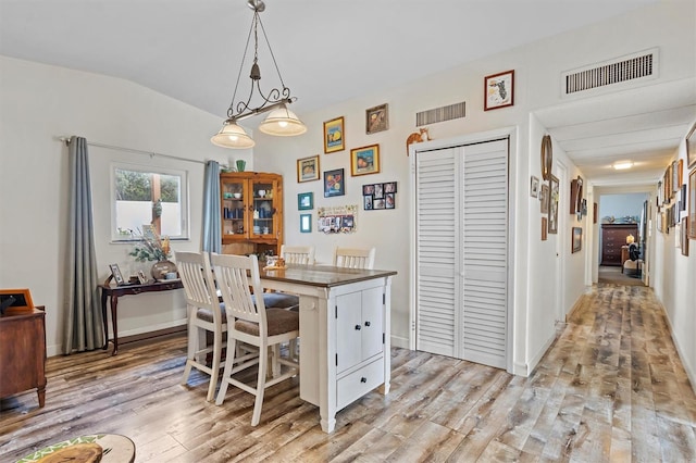 dining space featuring light hardwood / wood-style flooring and lofted ceiling