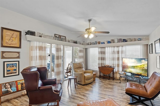 sitting room with ceiling fan, light wood-type flooring, and lofted ceiling