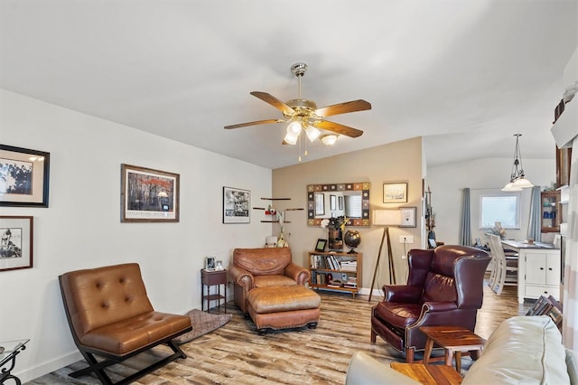 living room featuring vaulted ceiling, ceiling fan, and wood-type flooring