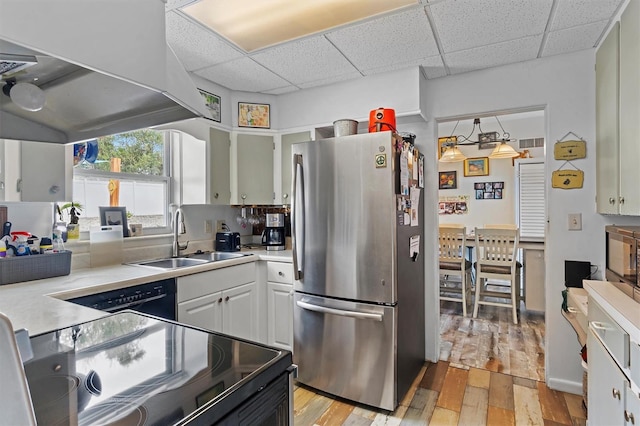 kitchen featuring black appliances, light wood-type flooring, sink, and white cabinets