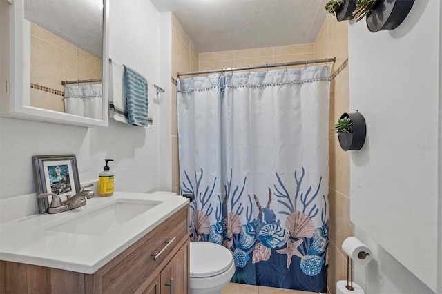 bathroom with toilet, a shower with curtain, vanity, and a textured ceiling