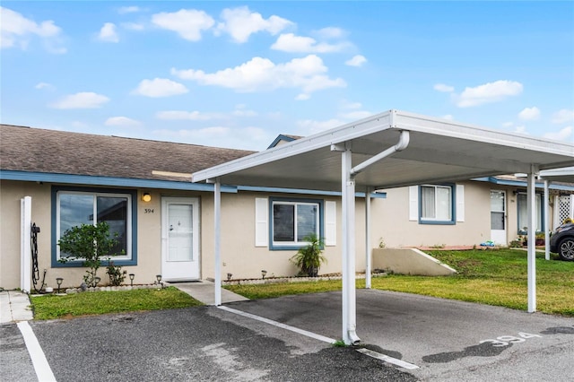 view of front of property with a carport and a front lawn