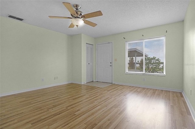 unfurnished room featuring a textured ceiling, ceiling fan, and light hardwood / wood-style flooring