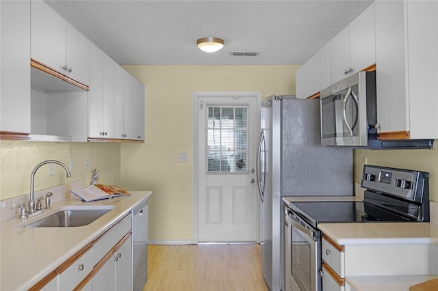 kitchen featuring white cabinets, sink, and appliances with stainless steel finishes