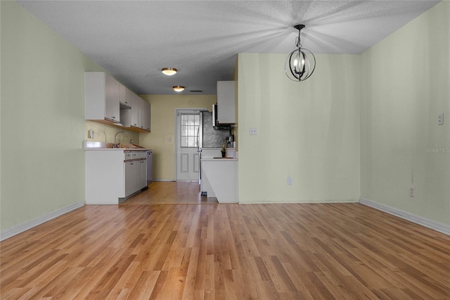 kitchen featuring hanging light fixtures, a textured ceiling, and light hardwood / wood-style floors