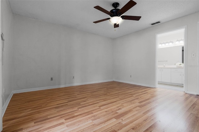 spare room with light hardwood / wood-style flooring, a textured ceiling, and ceiling fan