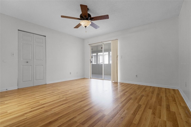 unfurnished bedroom with light wood-type flooring, a textured ceiling, and ceiling fan