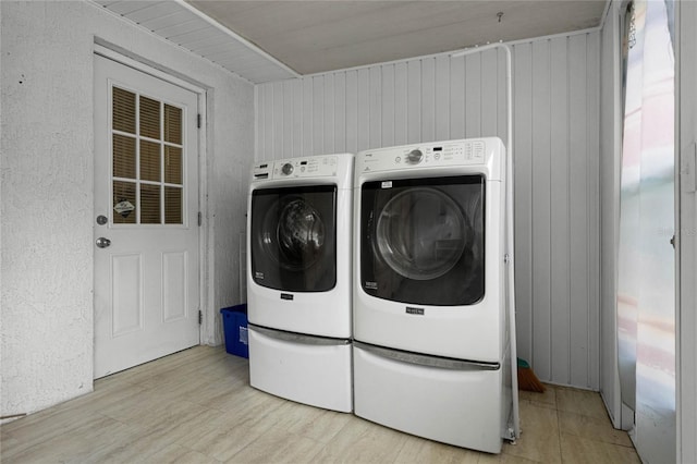 washroom with wooden walls and independent washer and dryer