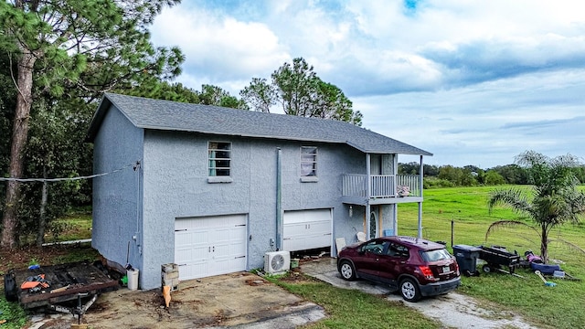 view of front of home with a garage, a front yard, and a balcony