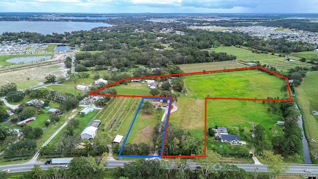 birds eye view of property featuring a water view and a rural view