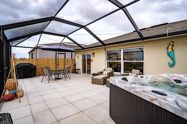 view of patio / terrace featuring a hot tub, glass enclosure, and area for grilling