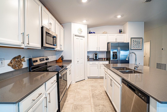 kitchen with appliances with stainless steel finishes, sink, an island with sink, and white cabinets