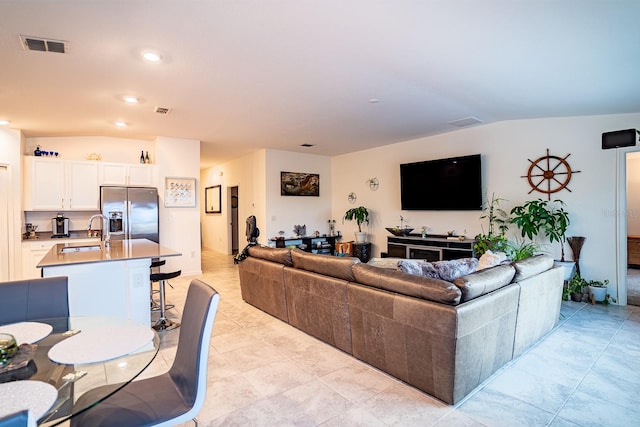 tiled living room with lofted ceiling and sink