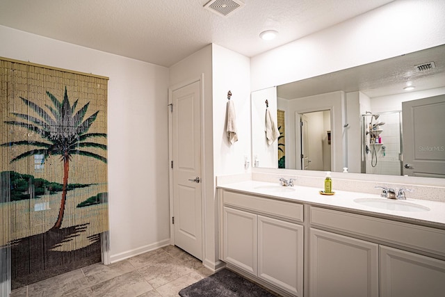 bathroom featuring vanity, a textured ceiling, and a shower with shower door