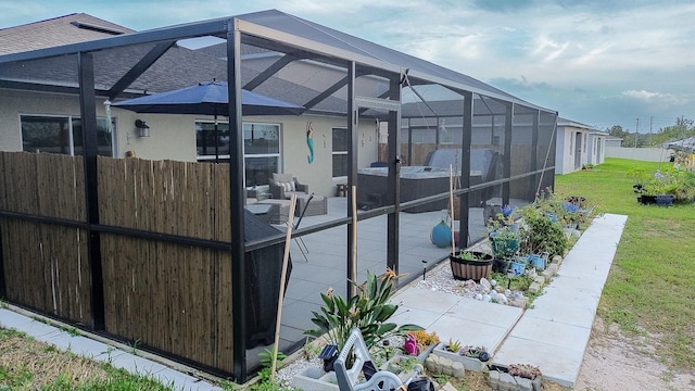 view of property exterior featuring glass enclosure, a patio, and a yard