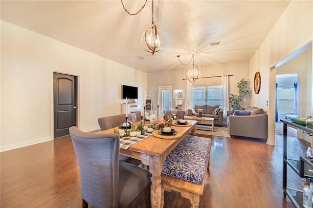 dining room featuring wood-type flooring and an inviting chandelier