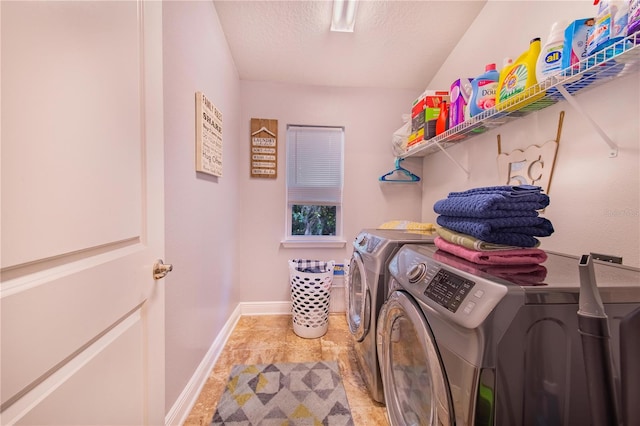 laundry area with washer and clothes dryer, a textured ceiling, and tile patterned flooring