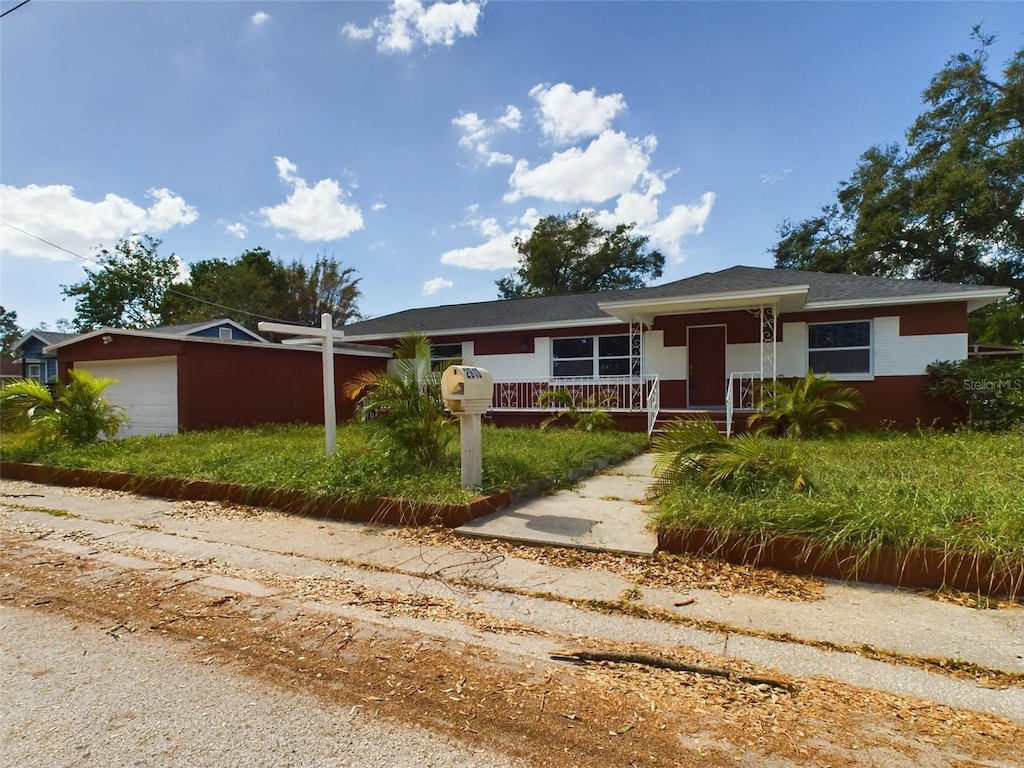 single story home featuring a garage and a porch