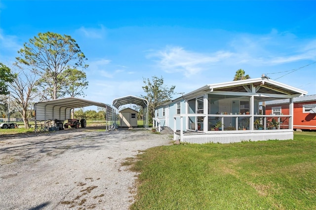 exterior space with a carport, a yard, a storage shed, and a sunroom