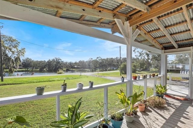 unfurnished sunroom featuring lofted ceiling with beams and a water view