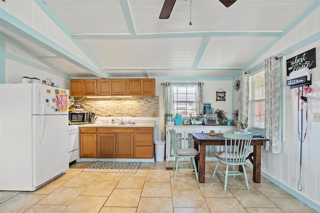 kitchen featuring white appliances, ceiling fan, sink, light tile patterned floors, and vaulted ceiling with beams