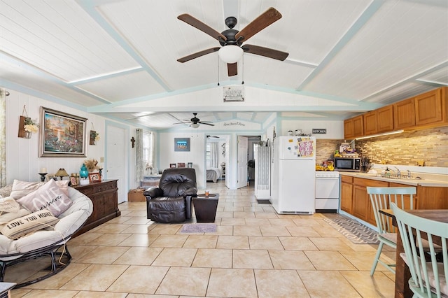 interior space with light tile patterned flooring, ceiling fan, and lofted ceiling with beams