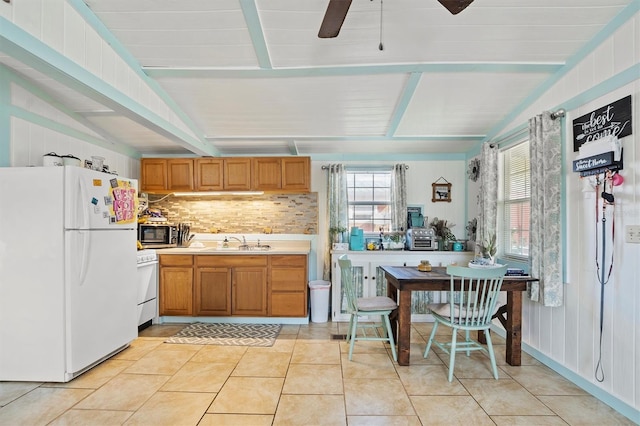 kitchen featuring sink, range, lofted ceiling with beams, white refrigerator, and backsplash