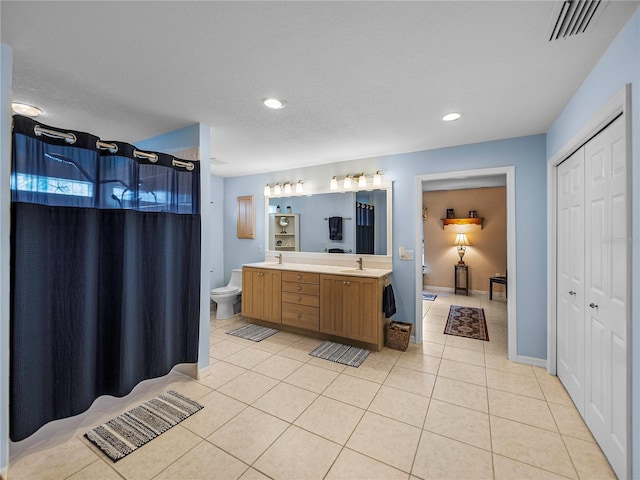 bathroom with tile patterned flooring, vanity, and toilet