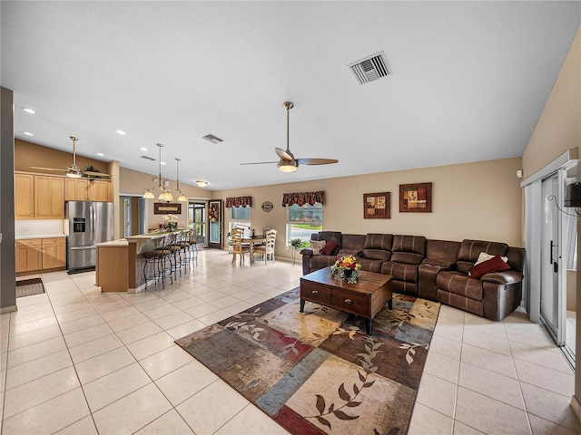 living room featuring light tile patterned flooring, ceiling fan, and vaulted ceiling