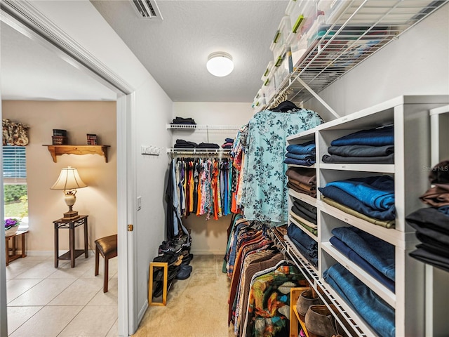 walk in closet with light tile patterned floors