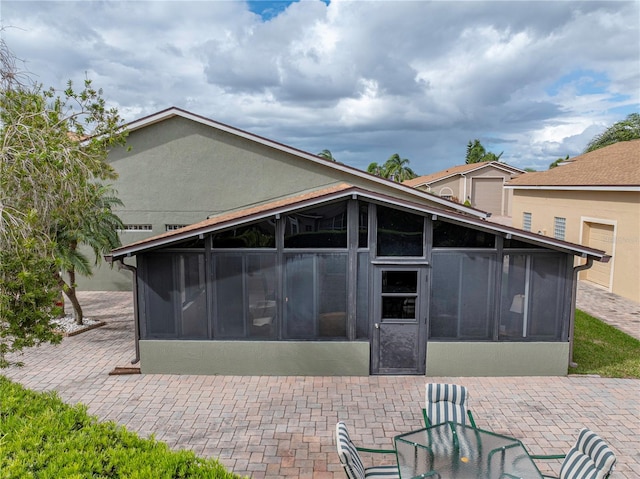 rear view of house with a patio area and a sunroom