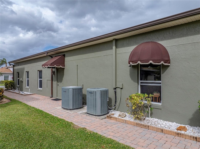 exterior space with a lawn and central air condition unit