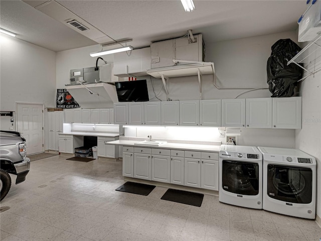 laundry area with cabinets, sink, a high ceiling, and washing machine and clothes dryer