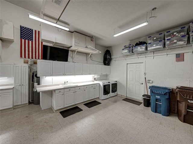 garage with separate washer and dryer, sink, and water heater