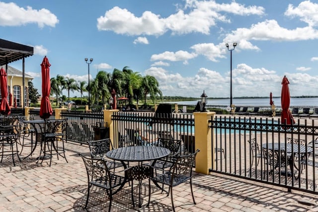 view of patio with a community pool and a water view