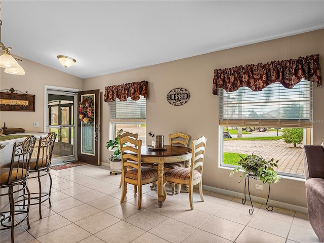 tiled dining area with vaulted ceiling