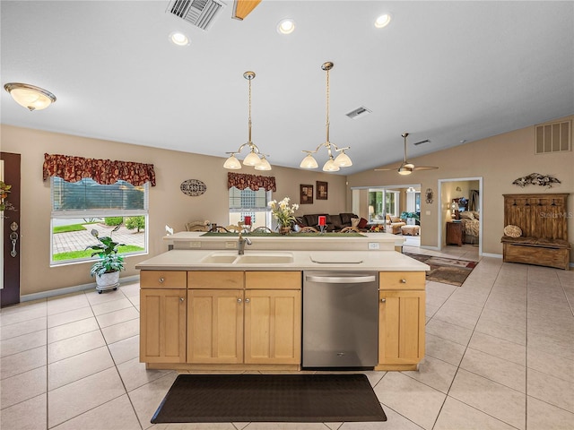 kitchen with sink, light brown cabinets, light tile patterned floors, stainless steel dishwasher, and a kitchen island with sink