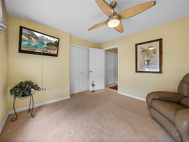 living area featuring carpet floors and ceiling fan