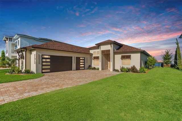 view of front of house with a garage and a yard