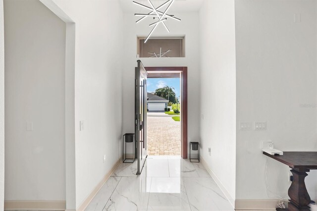 193 Stargrass Dr, Auburndale, FL 33823 - foyer featuring light marble finish flooring, baseboards, and a chandelier